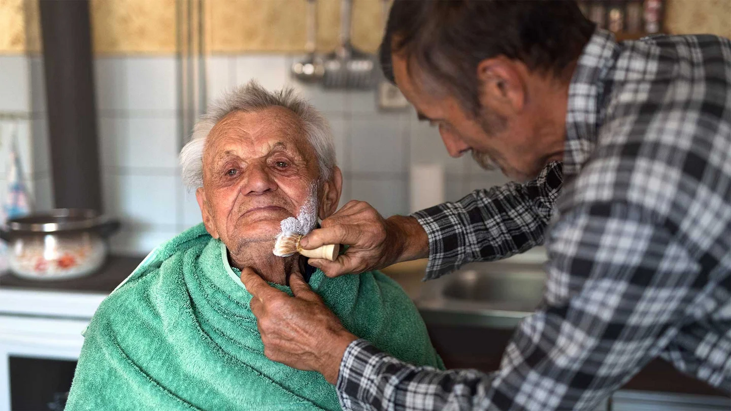 Ein &auml;lterer Herr wird rasiert. 
