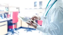 Ein Arzt &ouml;ffnet auf einem Tablet eine elektronische Patientenakte.